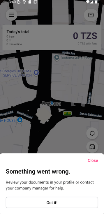 A ride-booking map screen is dimmed behind a “Something went wrong” dialog asking the user to review documents in their profile or contact their company manager. Visible: Today’s total, 0 trips, 0 m, 0 min online, 0 TZS, 0 TZS with fees.